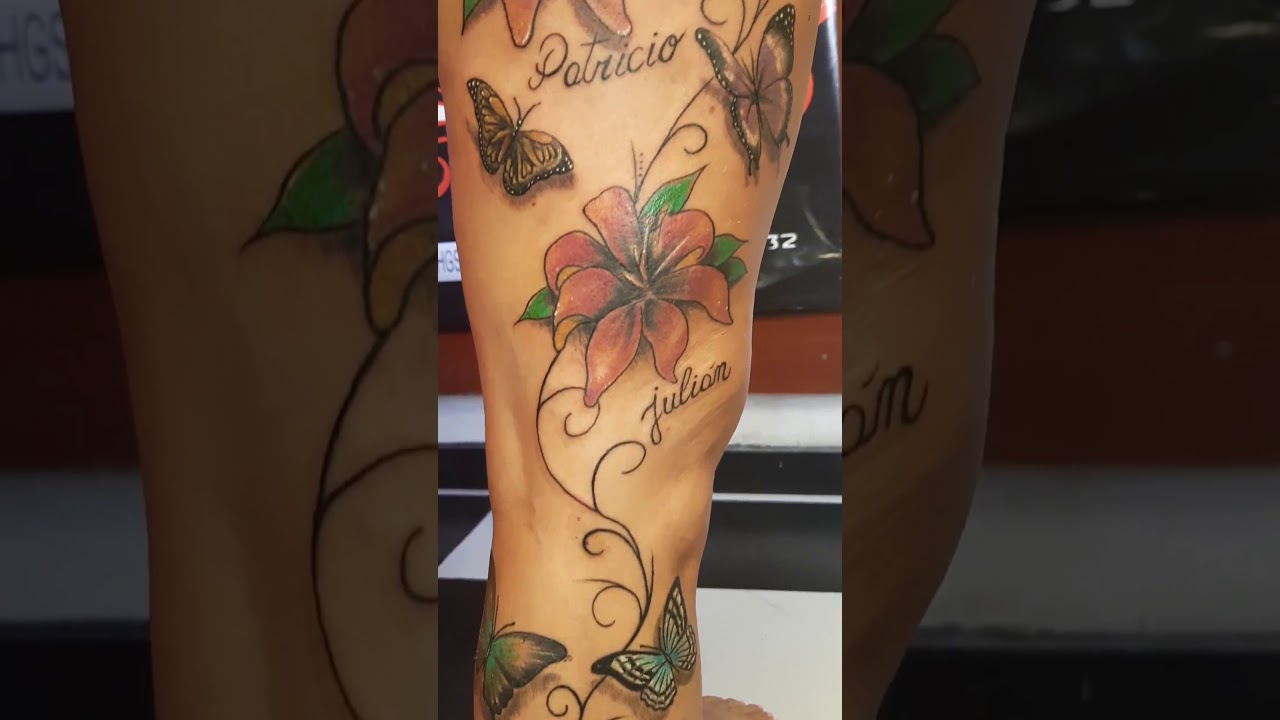 tatuajes de mariposas y flores en la pierna